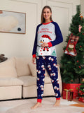 Woman modeling a white snowman Christmas top with navy sleeves and navy snowman-print pants.
