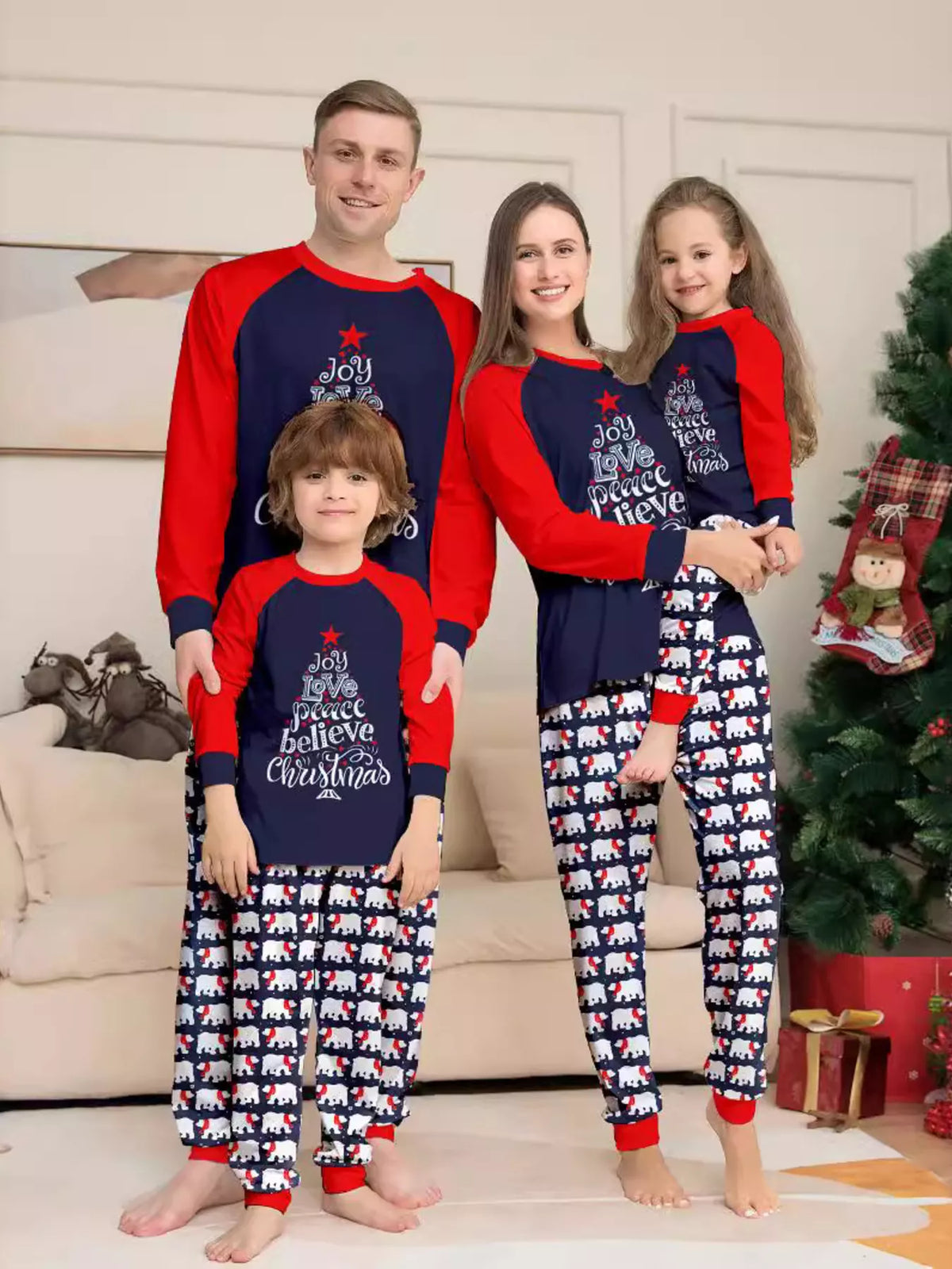 Navy and red Christmas graphic pajama top with matching festive-print pants worn by a family