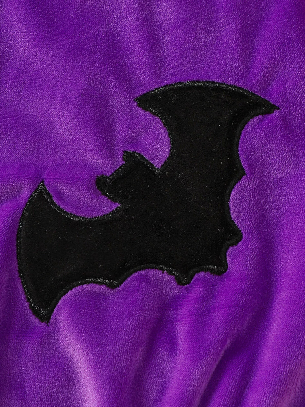 Black bat applique on purple baby bodysuit fabric
