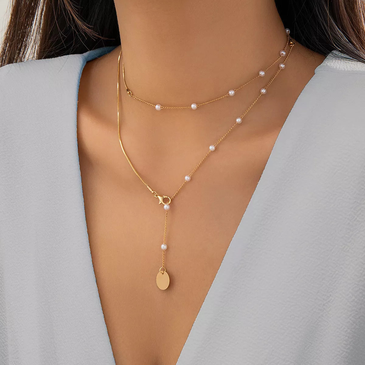 Gold-tone pearl-like station necklace with coin pendant