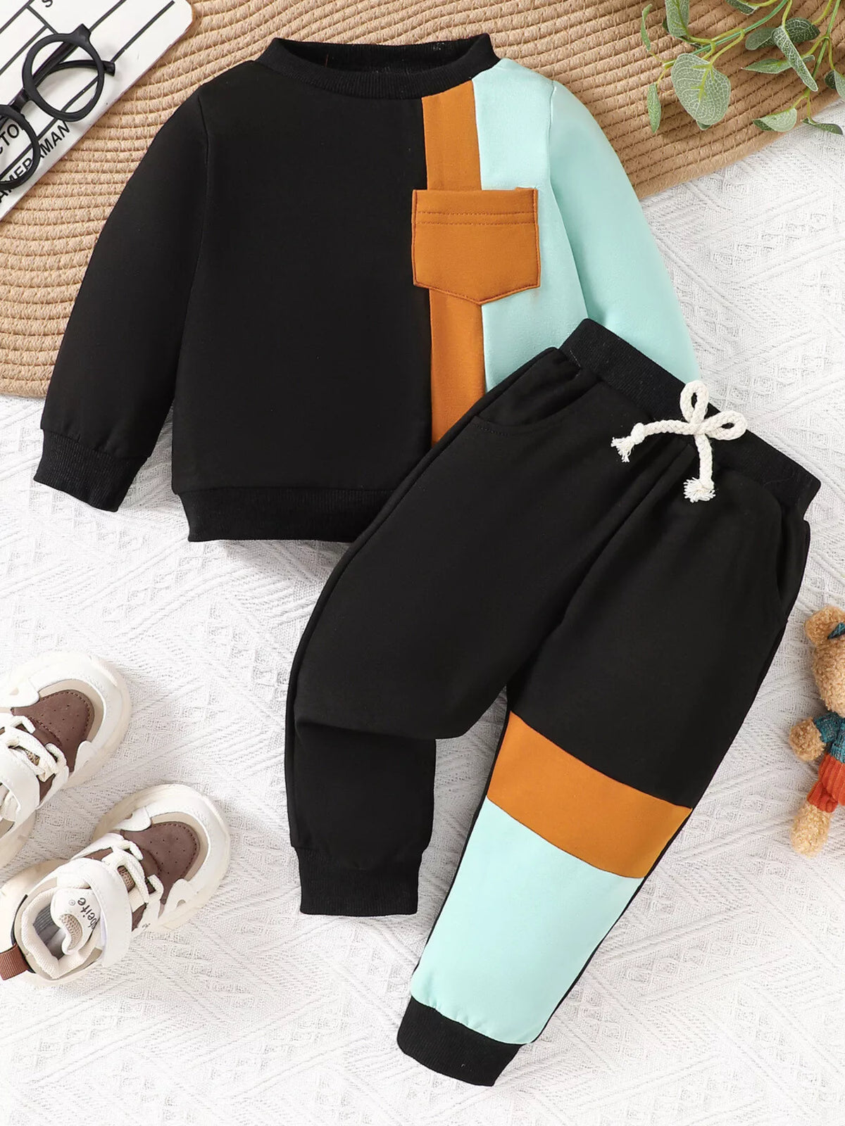 Black, orange and mint color-block sweatshirt and matching joggers laid flat