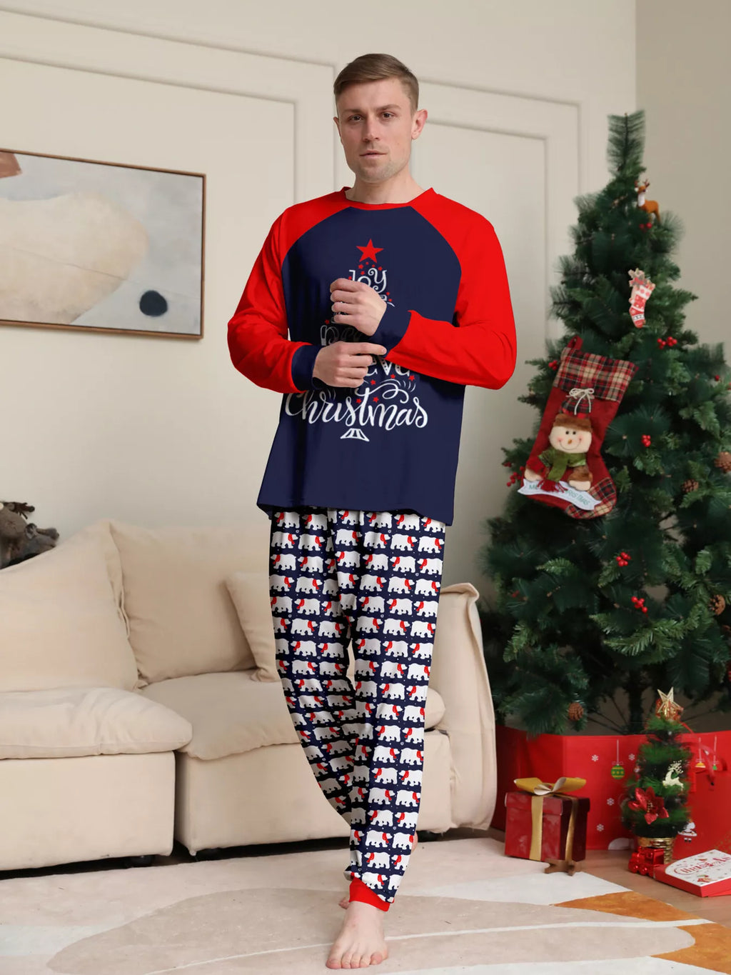 Navy and red Christmas graphic pajama top with matching festive-print pants worn by an adult