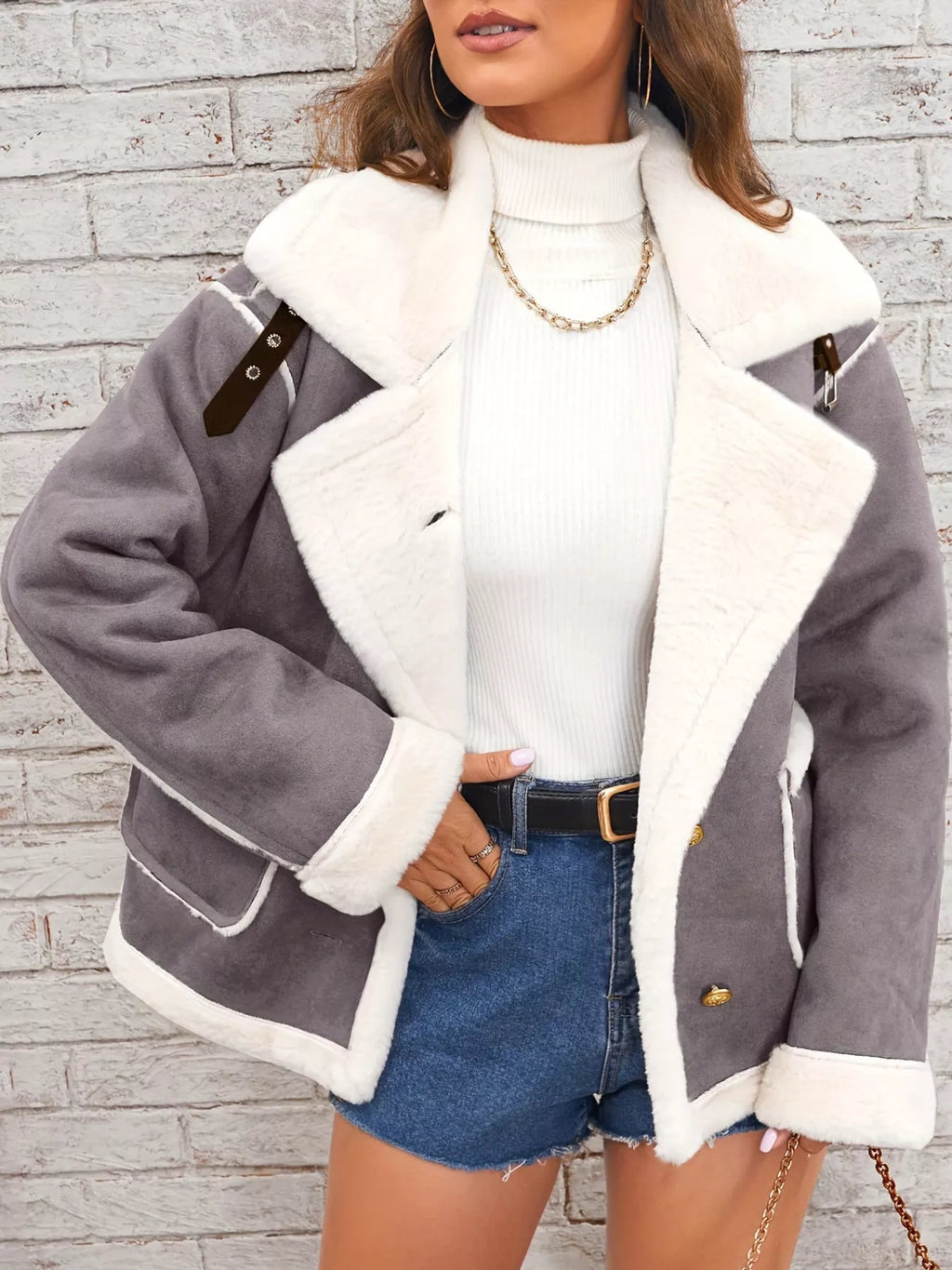 Dark-gray jacket with wide white plush lapels, contrast trim and front pockets, front view modeled with a hand at the hip.