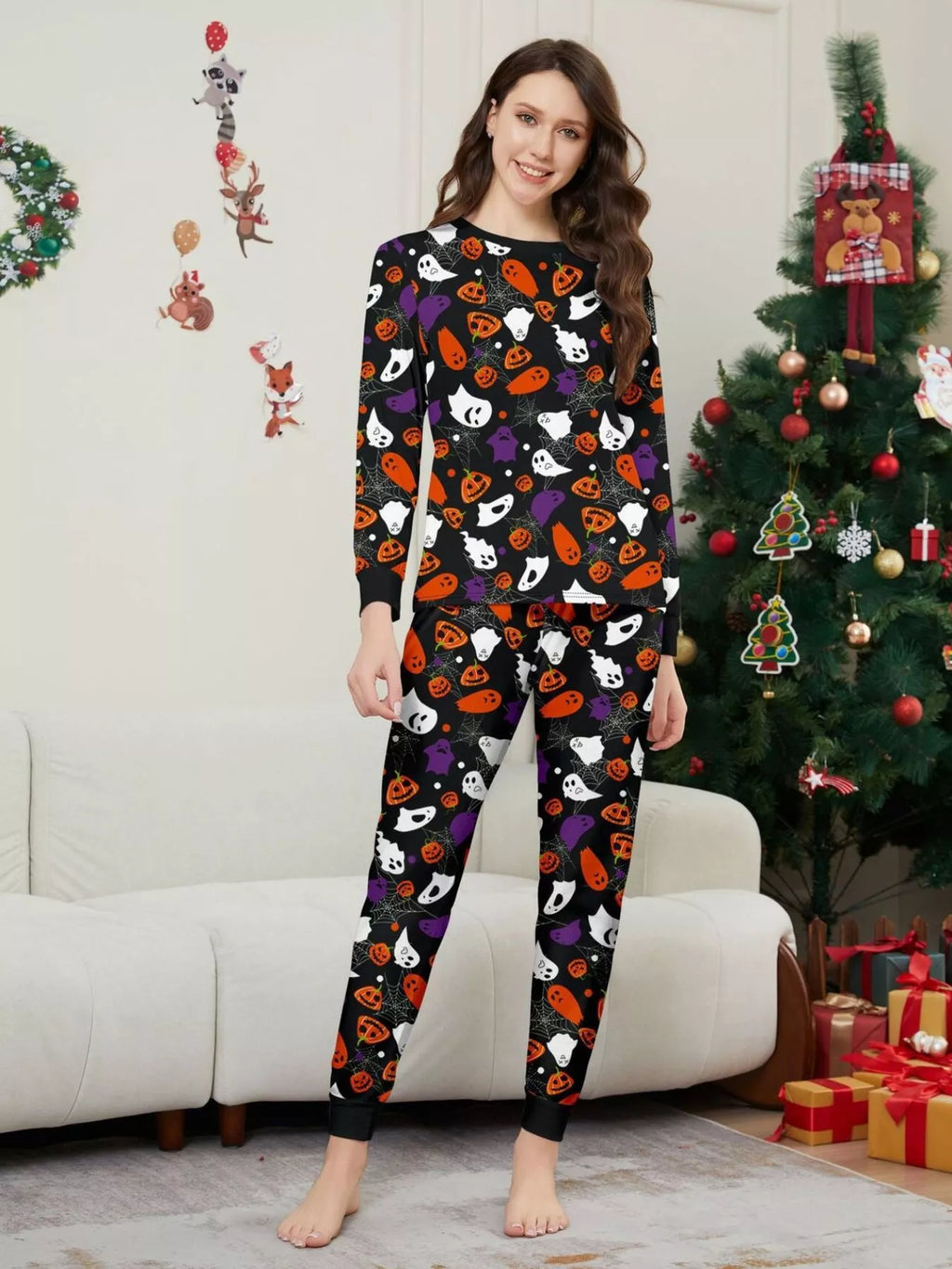 Black matching family pajamas with colorful Halloween ghost and pumpkin print worn by an adult