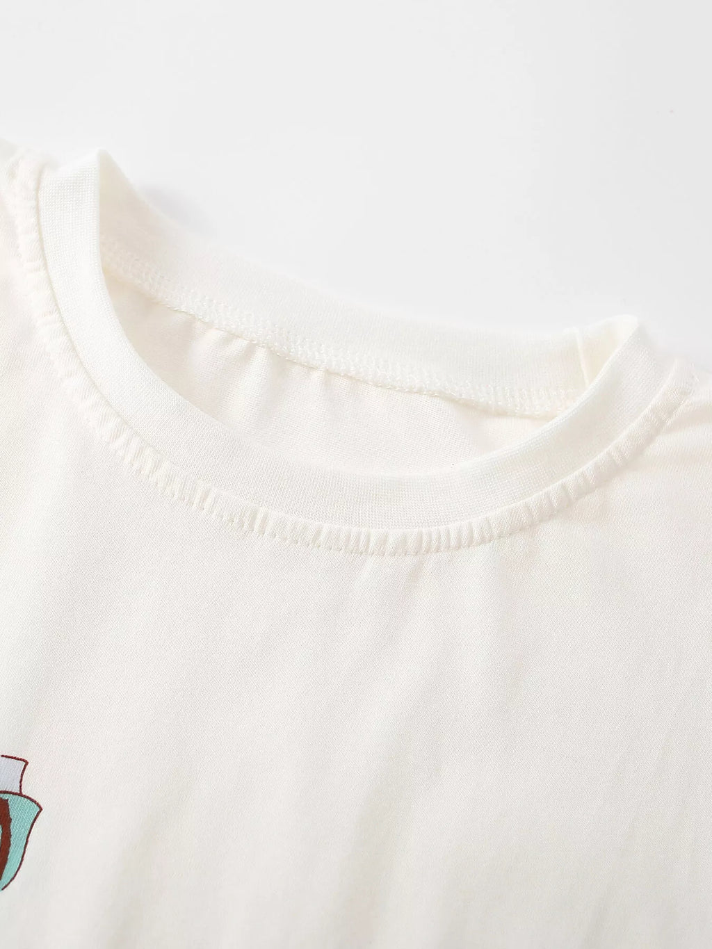 Close-up of the cream top's rounded neckline.
