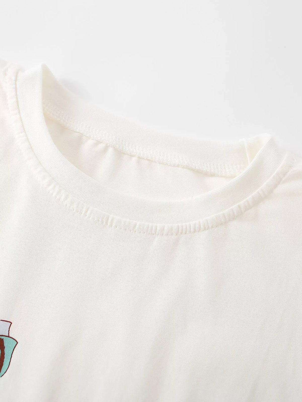 Close-up of the cream top's rounded neckline.