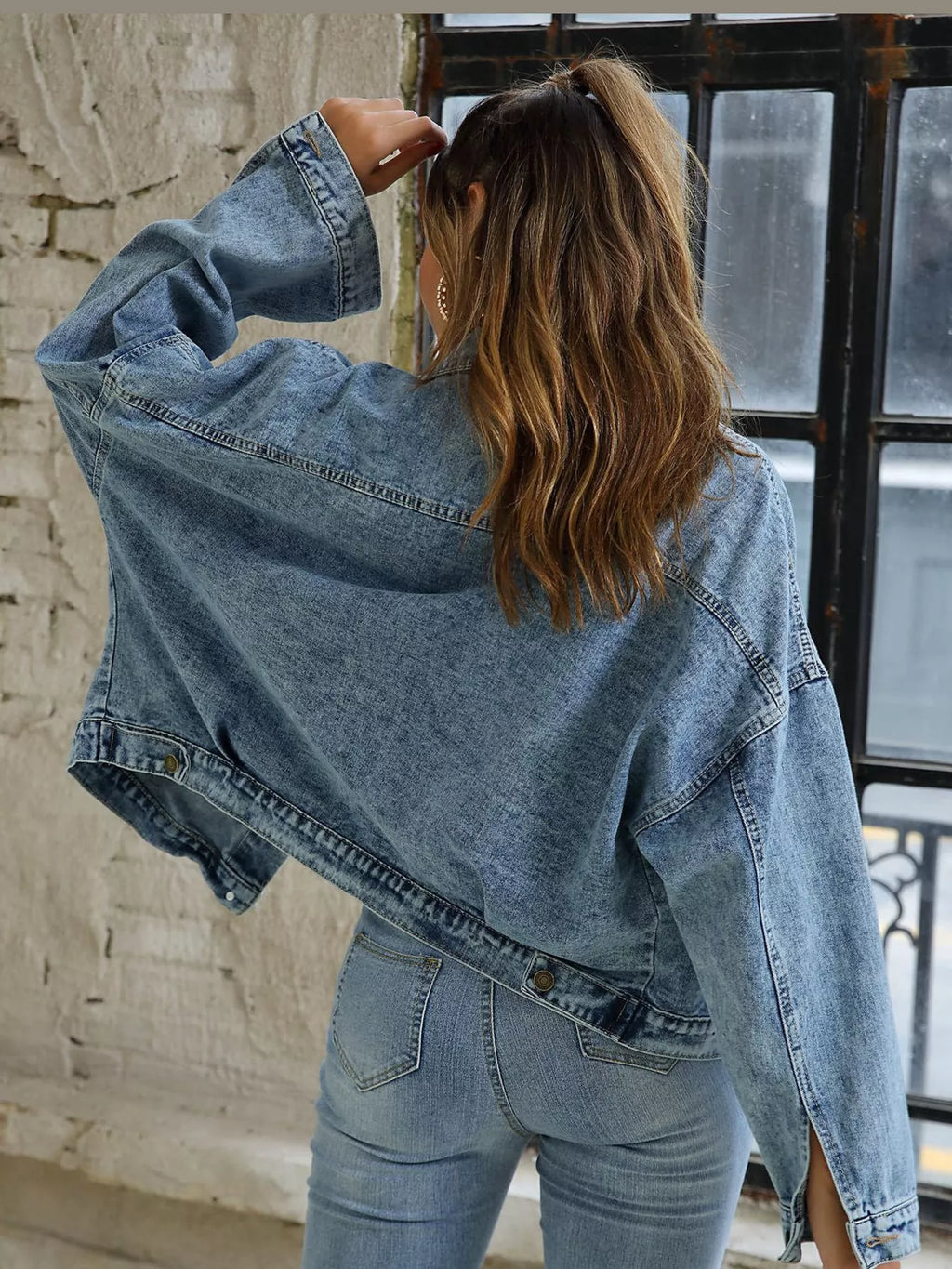 Back view of the oversized light-blue denim jacket.