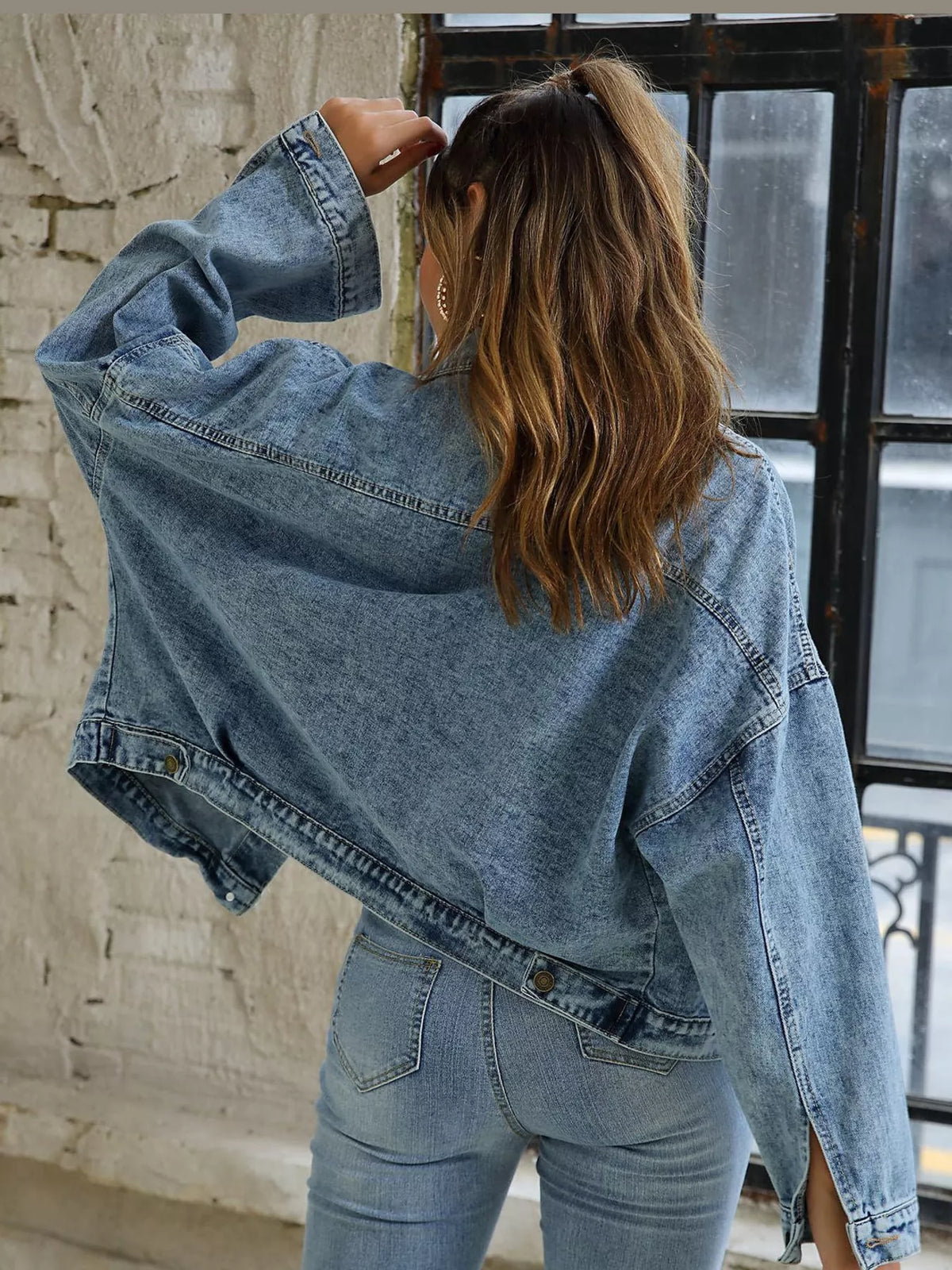Back view of the oversized light-blue denim jacket.