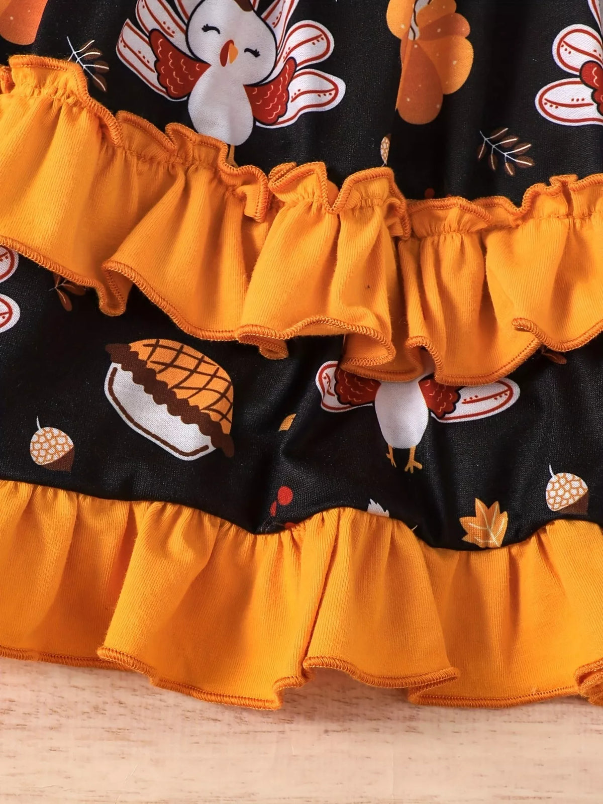 Orange ruffle tiers and turkey print on the black dress skirt