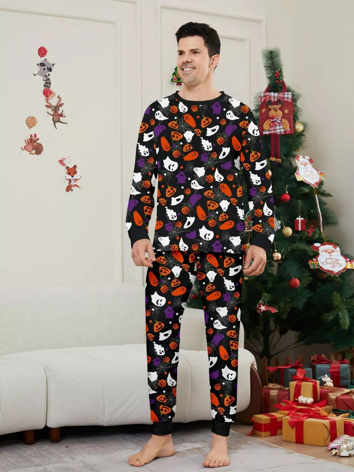 Black matching family pajamas with colorful Halloween ghost and pumpkin print worn by an adult