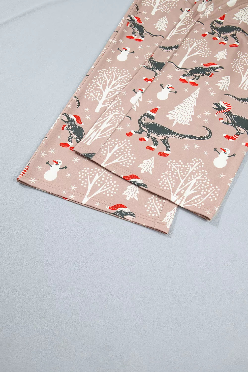 Pink long-sleeve pajama shirt and pants with dinosaur Christmas print — detail view