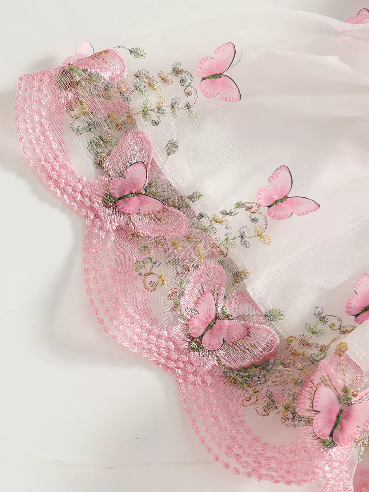 Close-up of butterfly and floral trim along the white tulle skirt's pink hem.