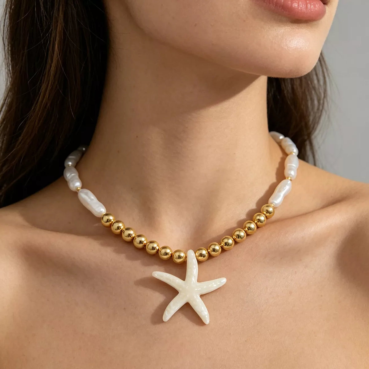 Starfish pendant necklace with gold-tone beads and white shell-like links