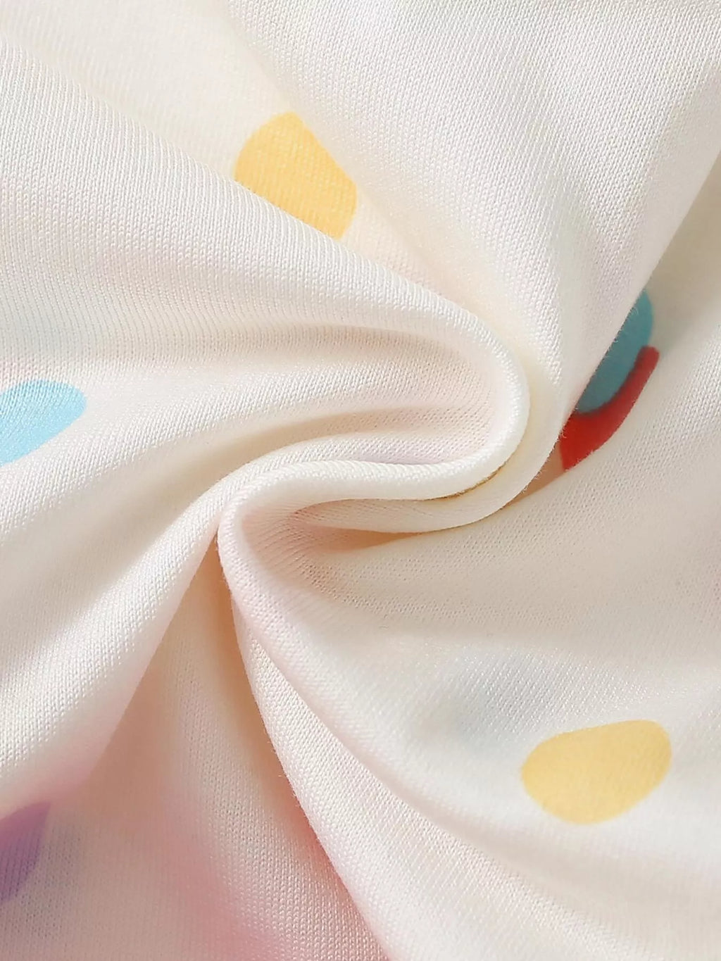 Multicolor polka-dot fabric detail on the white top
