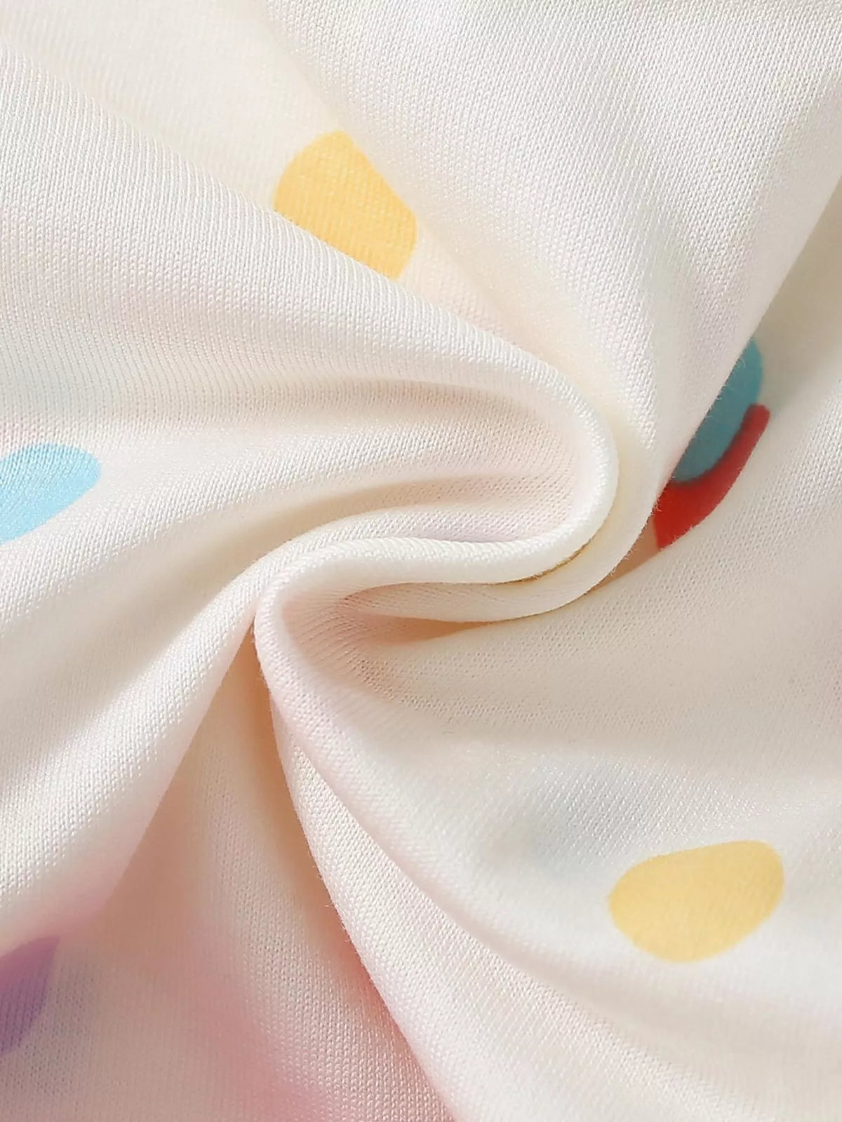 Multicolor polka-dot fabric detail on the white top