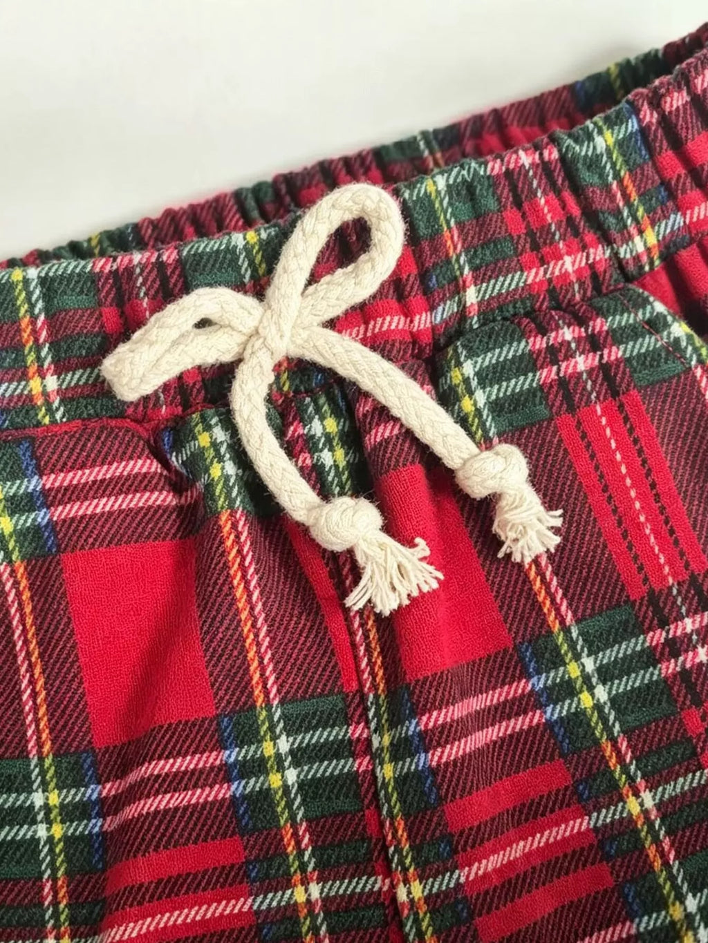 Drawstring waistband and red plaid fabric of the children’s pants