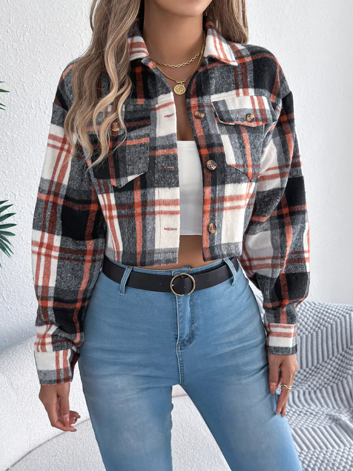 Black, white and rust plaid cropped button-up jacket with chest pockets, front view.