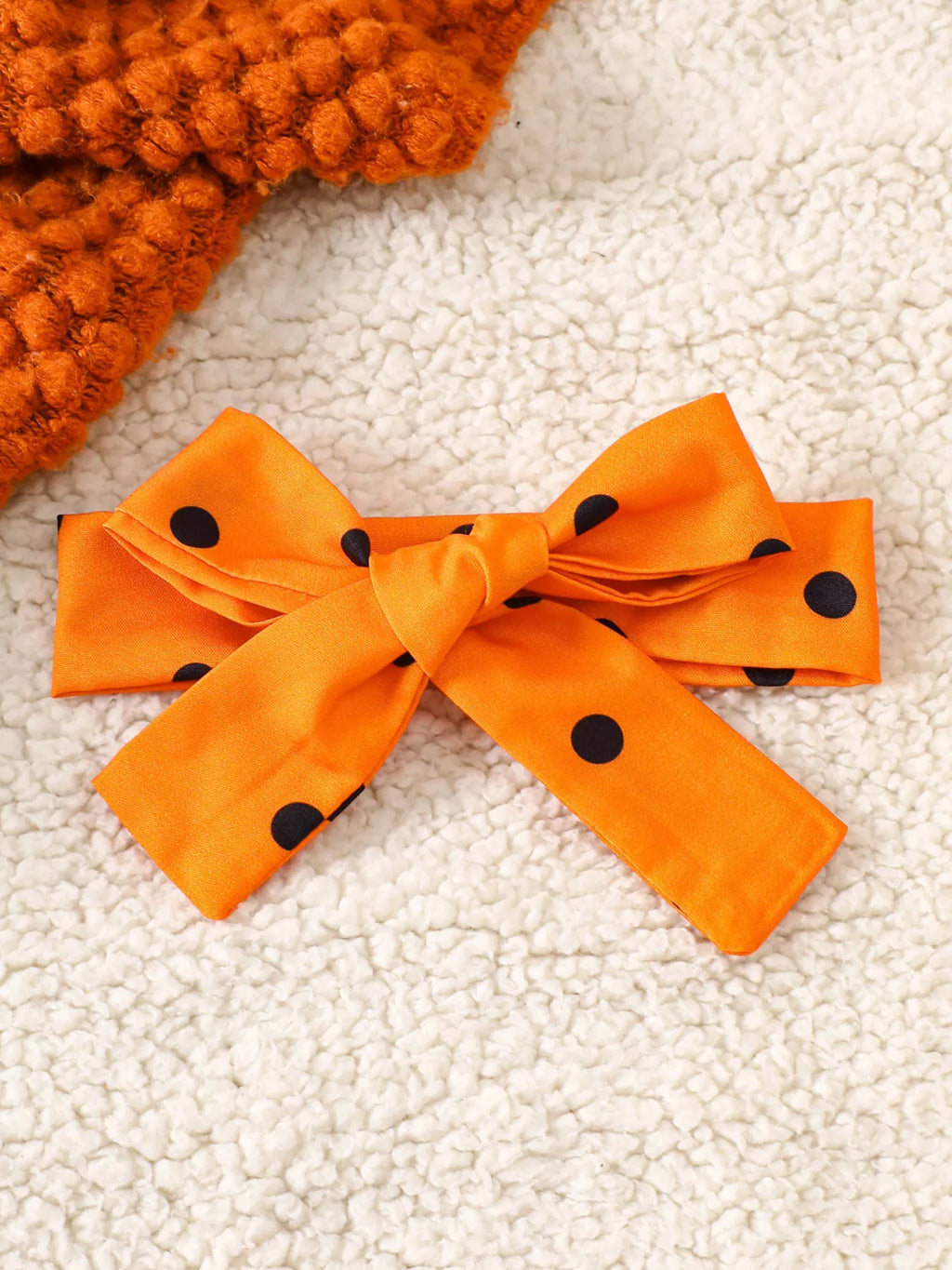 Close-up of the orange polka-dot bow headband.