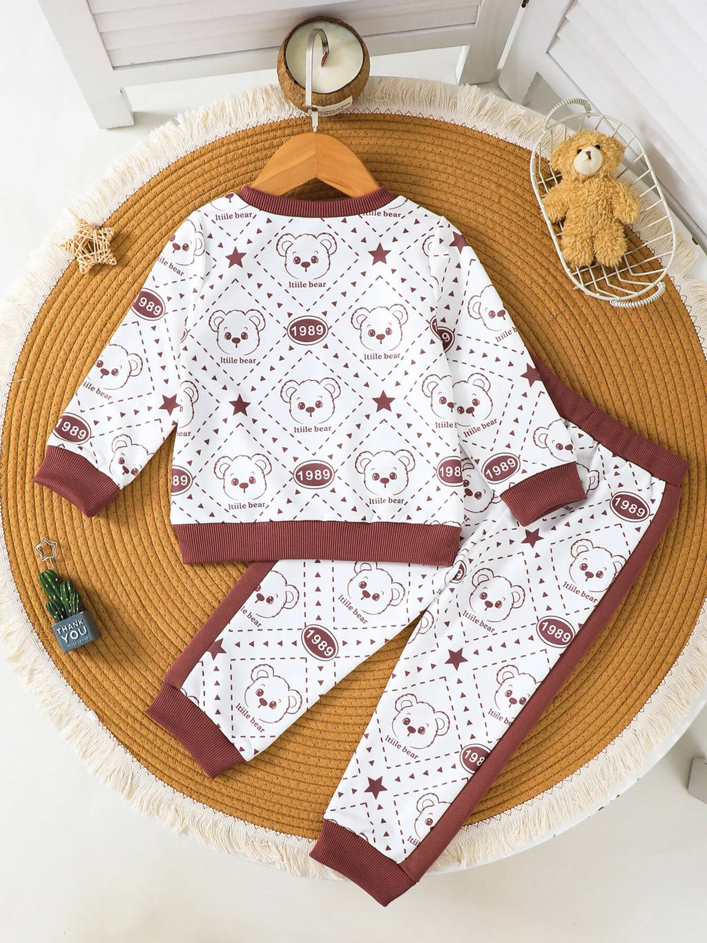 Children’s cream and maroon bear-print sweatshirt and matching pants displayed flat