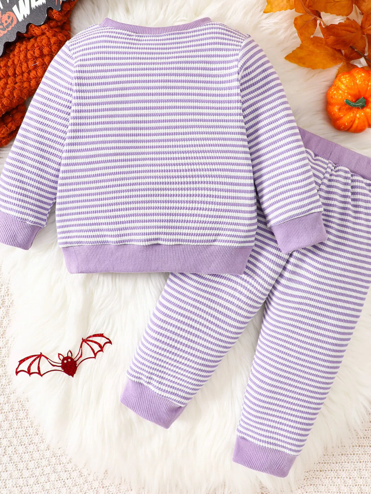 Purple striped BOO BABE pajama top and matching Halloween-print pants displayed flat