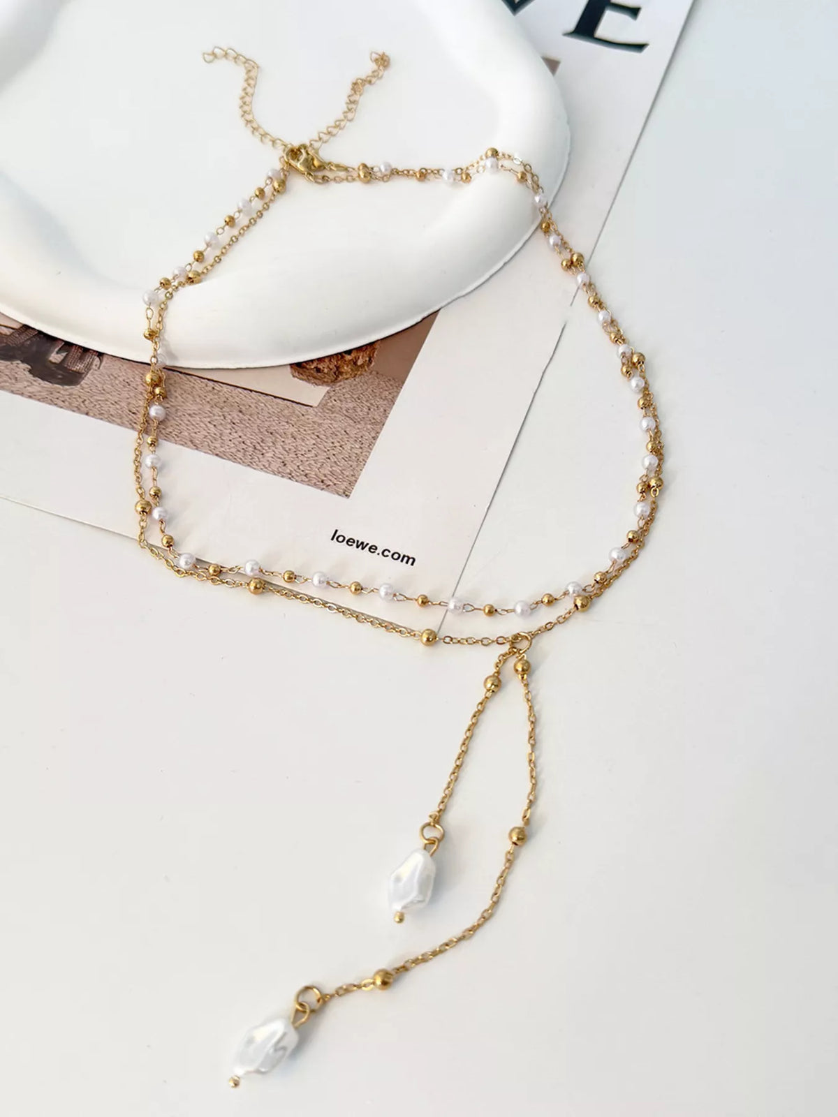 Gold-tone layered Y-shaped necklace with pearl-like pendants — detail view
