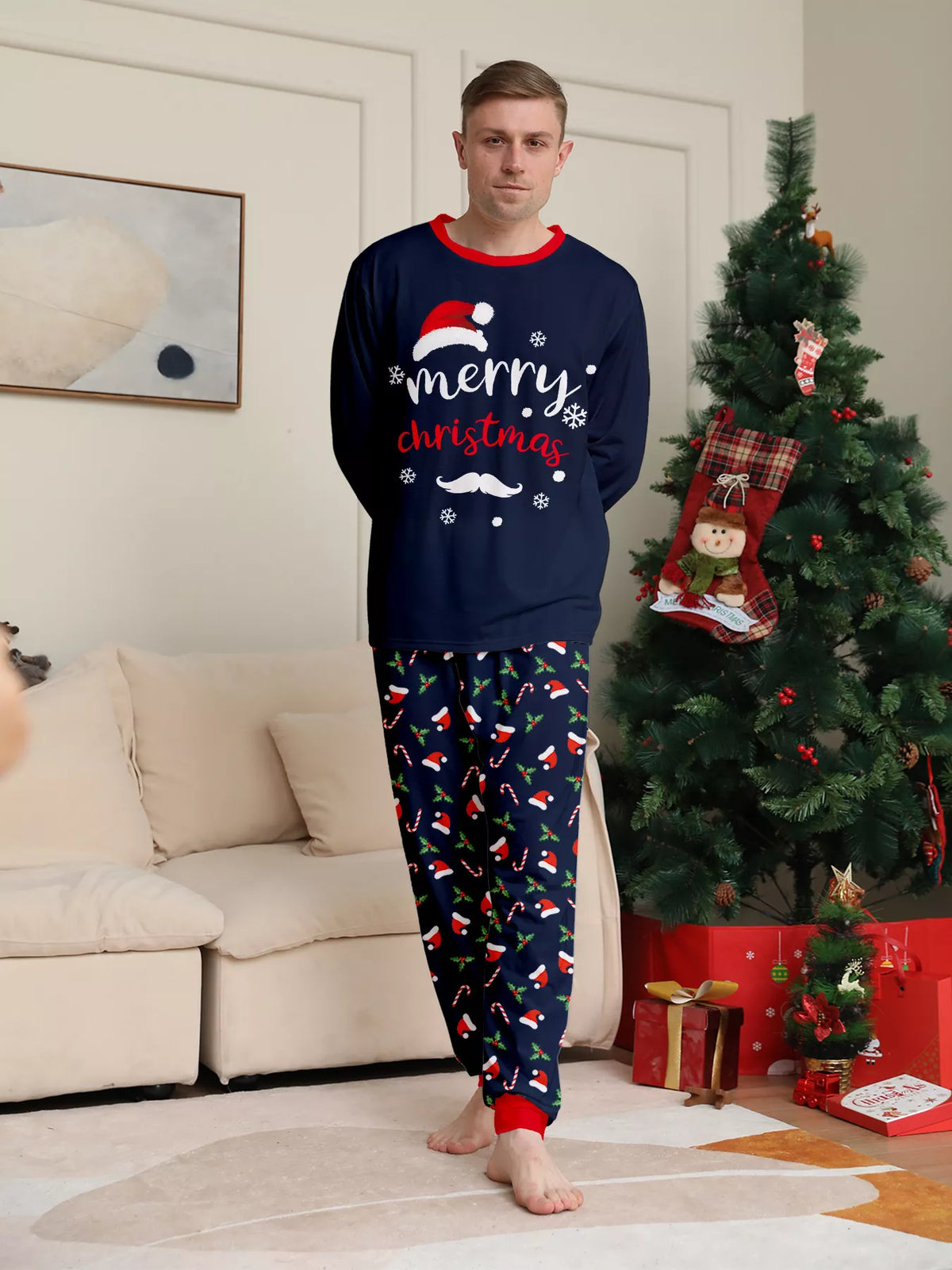 Man wearing the navy Merry Christmas top and festive printed pajama pants.