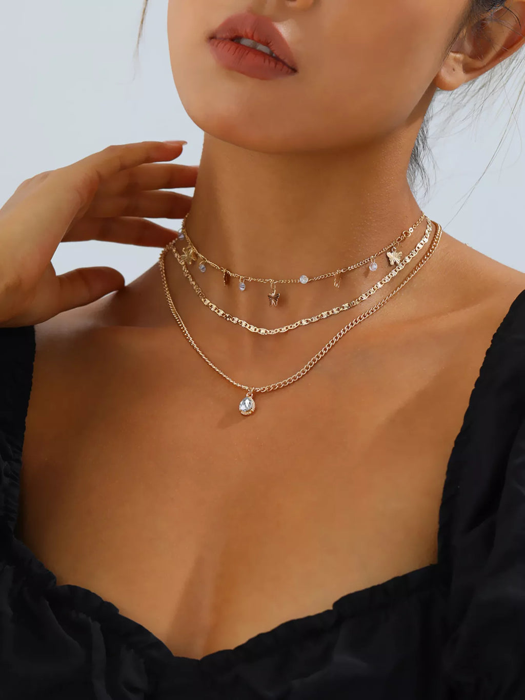 Layered gold-tone necklace with butterfly and clear stone charms