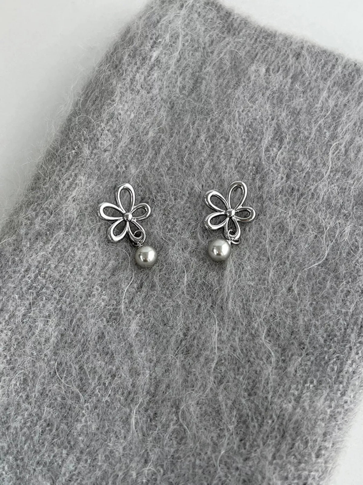 Flower-shaped drop earrings with pearl-like beads — detail view