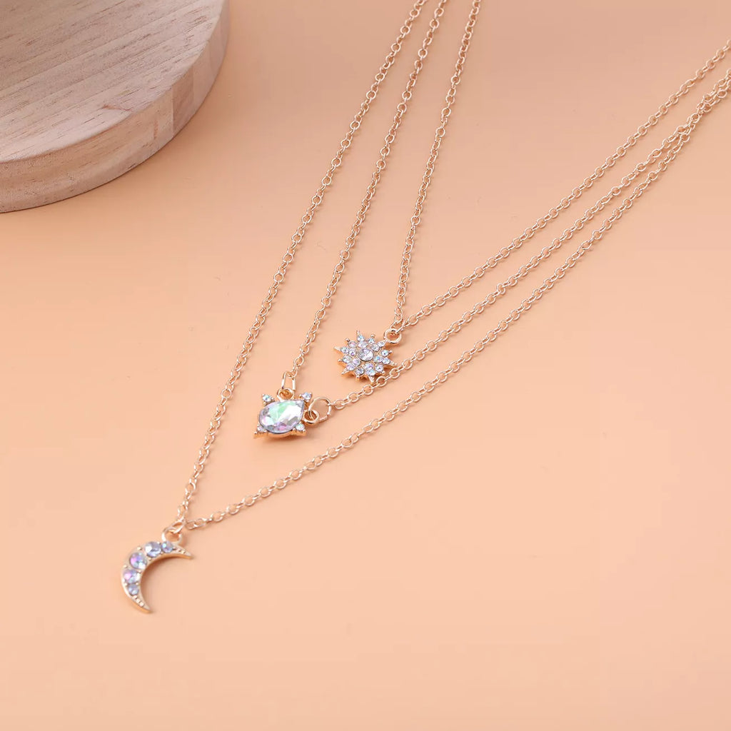 Layered silver-tone necklace with celestial and clear stone charms — detail view