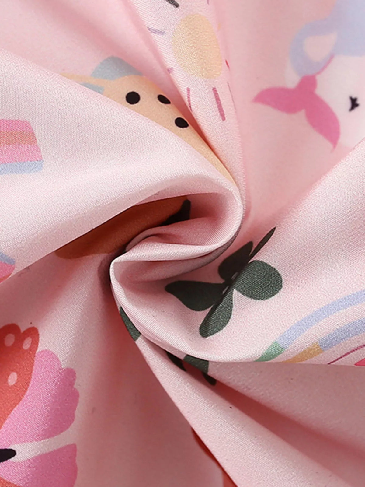 Folded pink jacket fabric showing colorful illustrated prints.