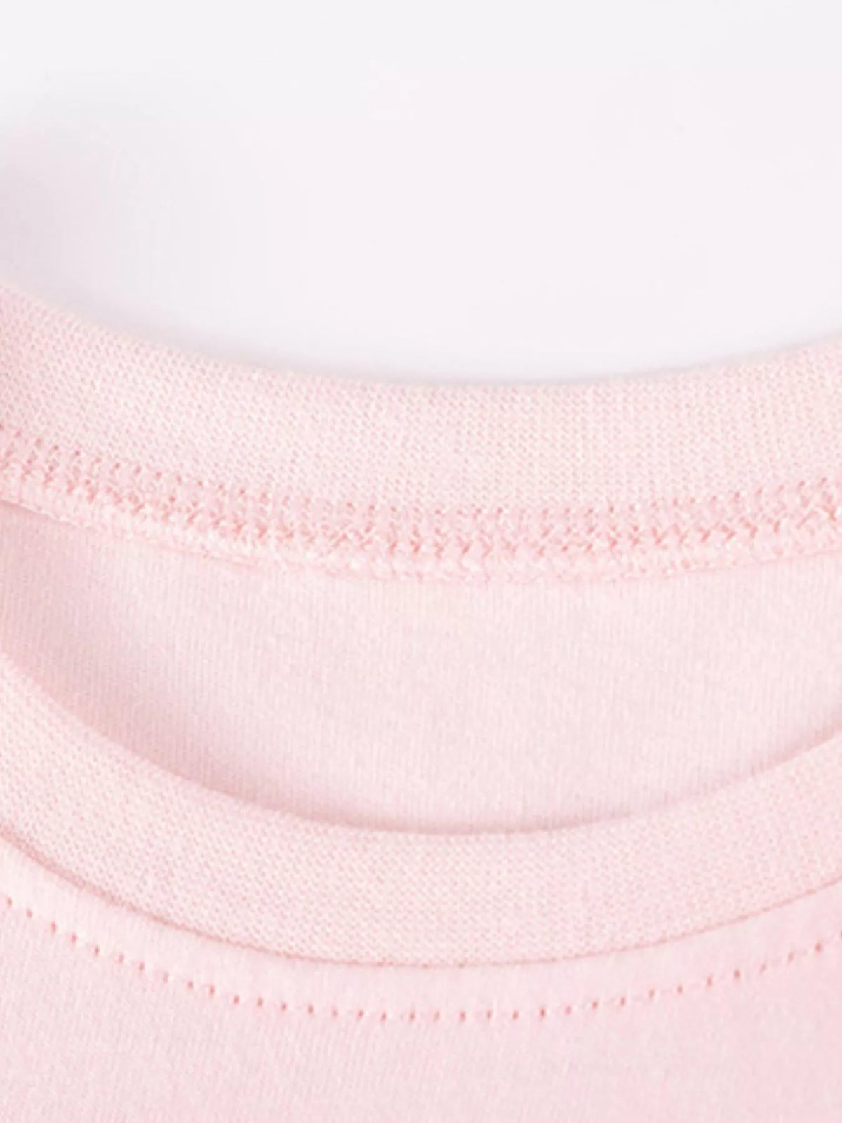 Close-up of the ribbed pink crew neckline and stitching.