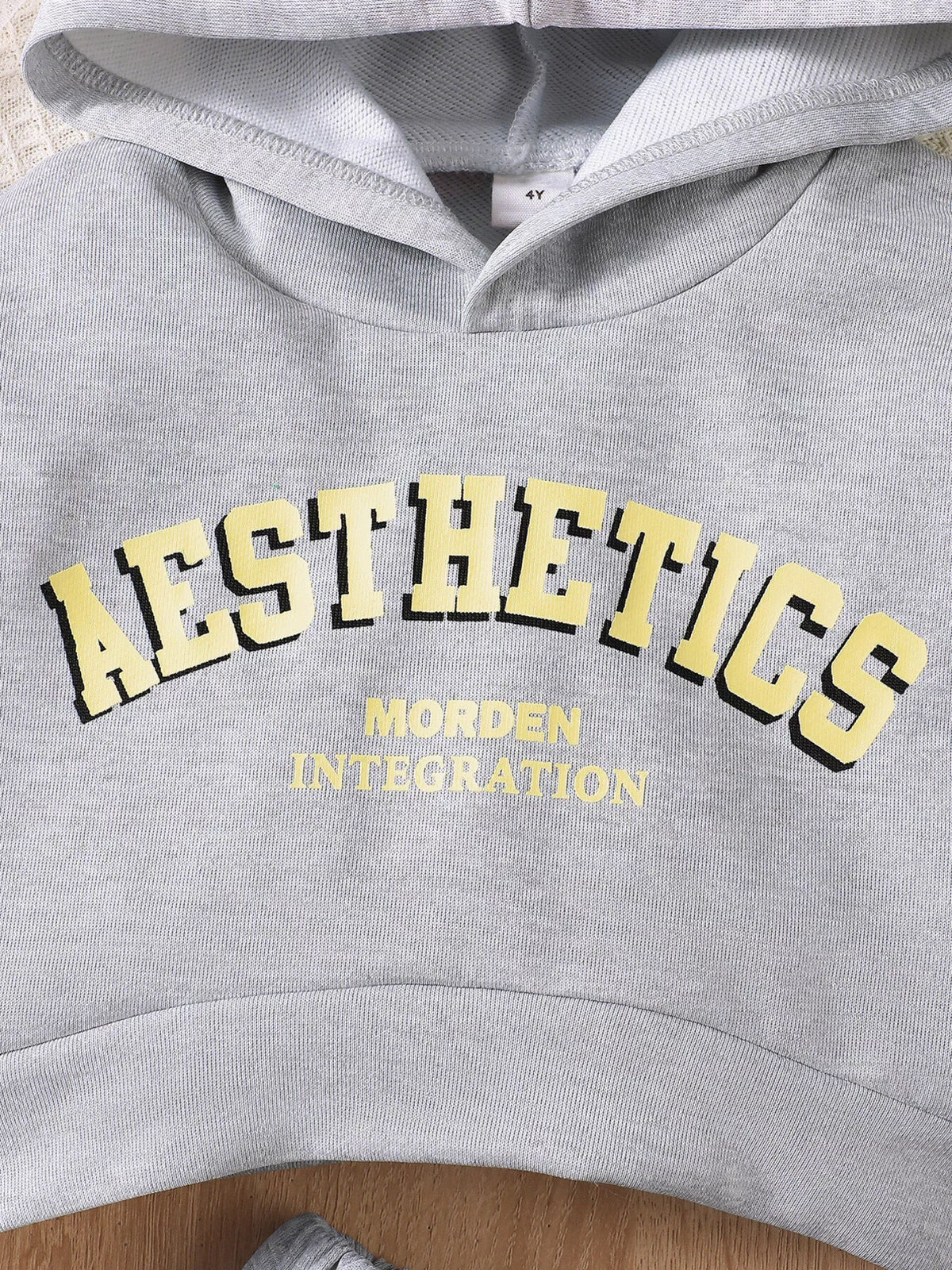 Yellow AESTHETICS lettering on the gray hoodie