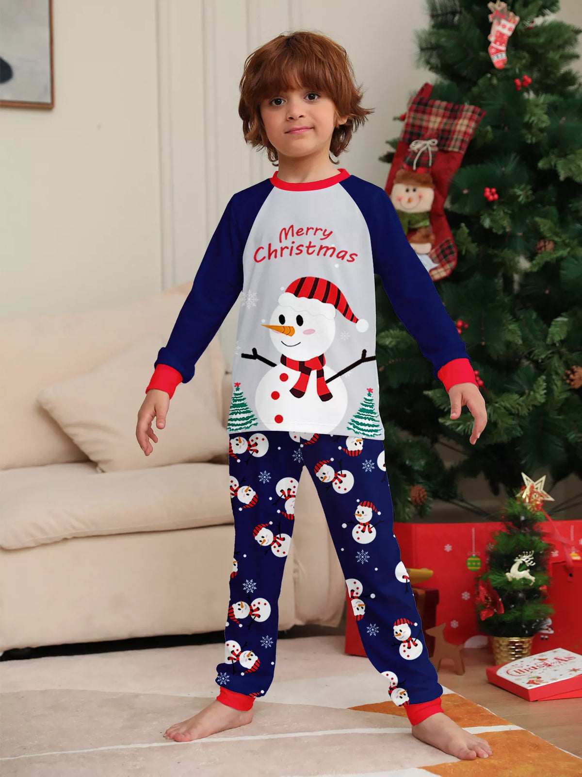 Child modeling the white snowman top with navy sleeves and navy printed pants.