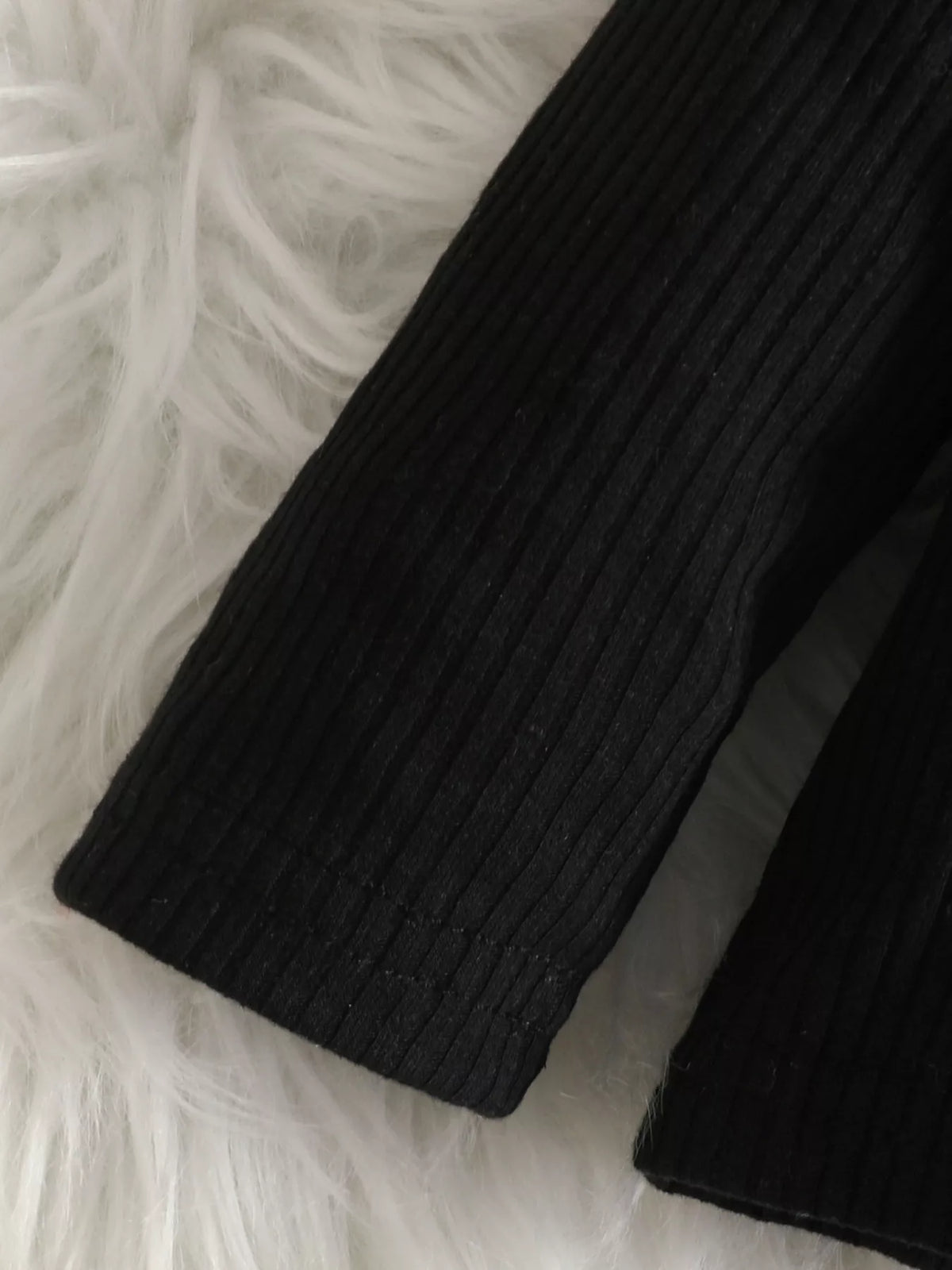 Close-up of the black top's ribbed sleeve.