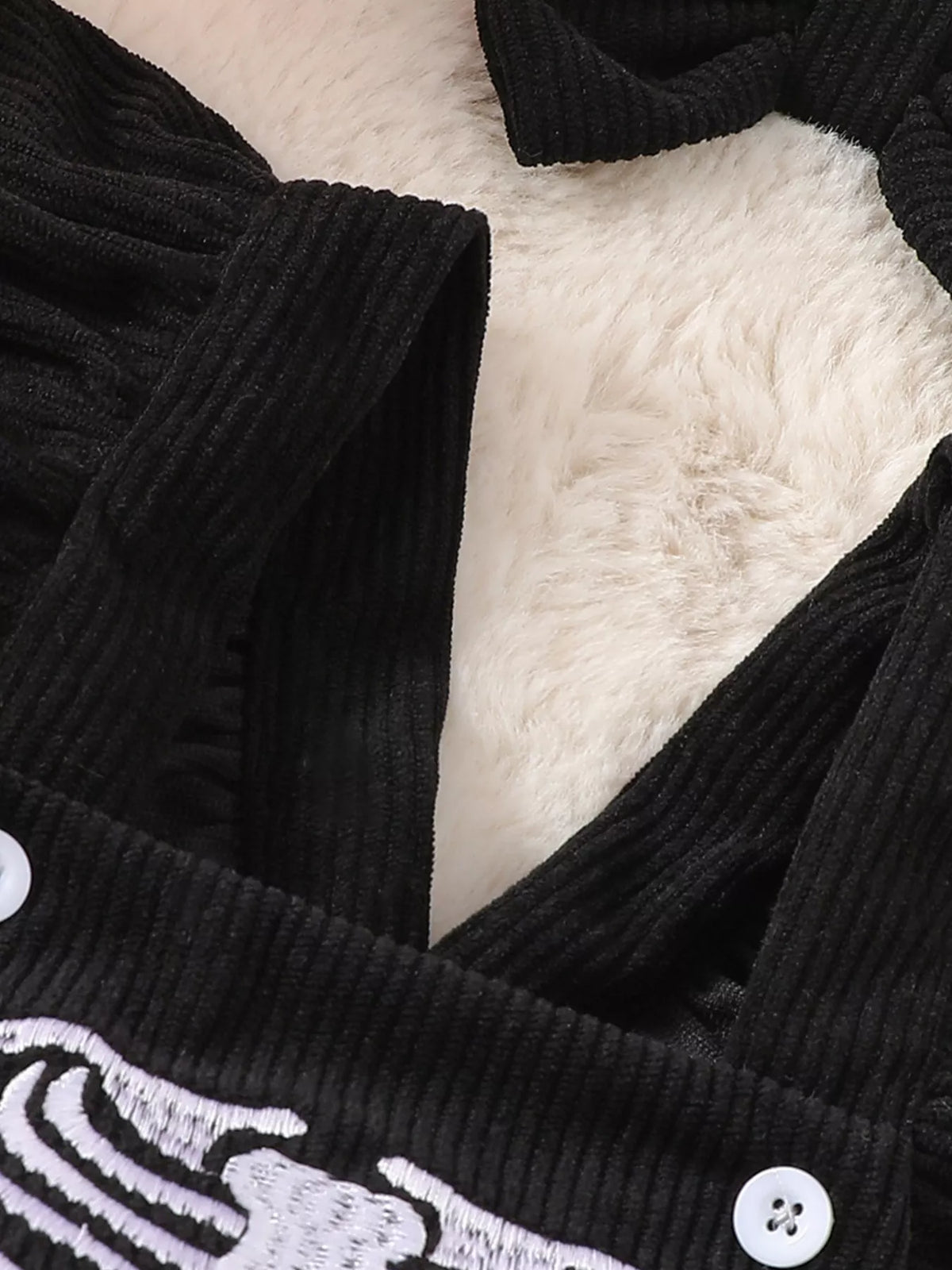 Ribbed black neckline and ruffle strap of the skeleton bodysuit
