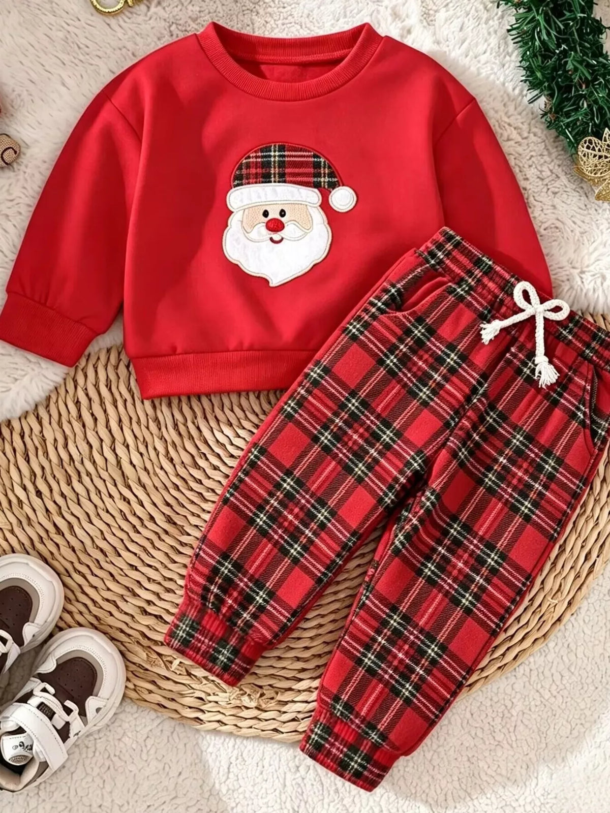 Children’s red Santa graphic sweatshirt and red plaid pants displayed flat