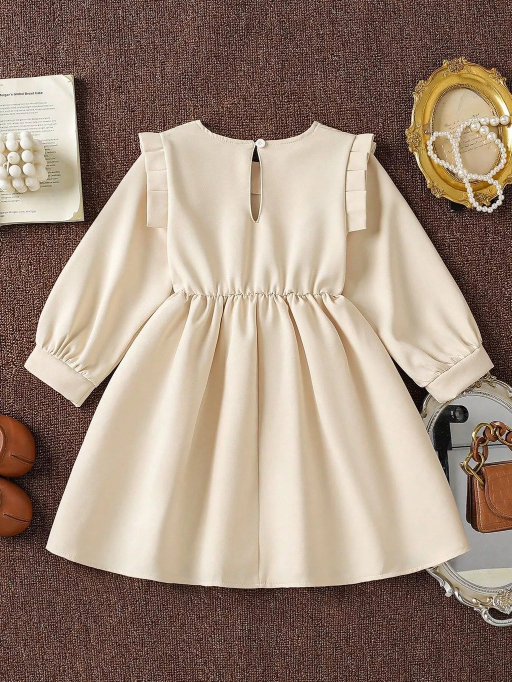 Back view of the cream long-sleeve dress with a short neckline opening.