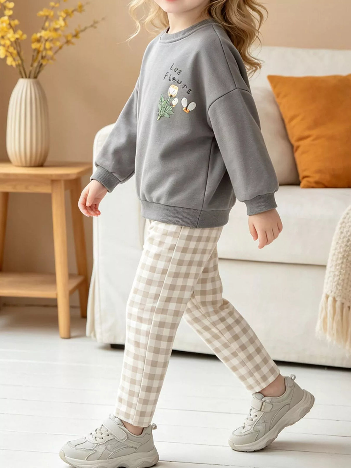Gray graphic sweatshirt and beige plaid pants worn by a child