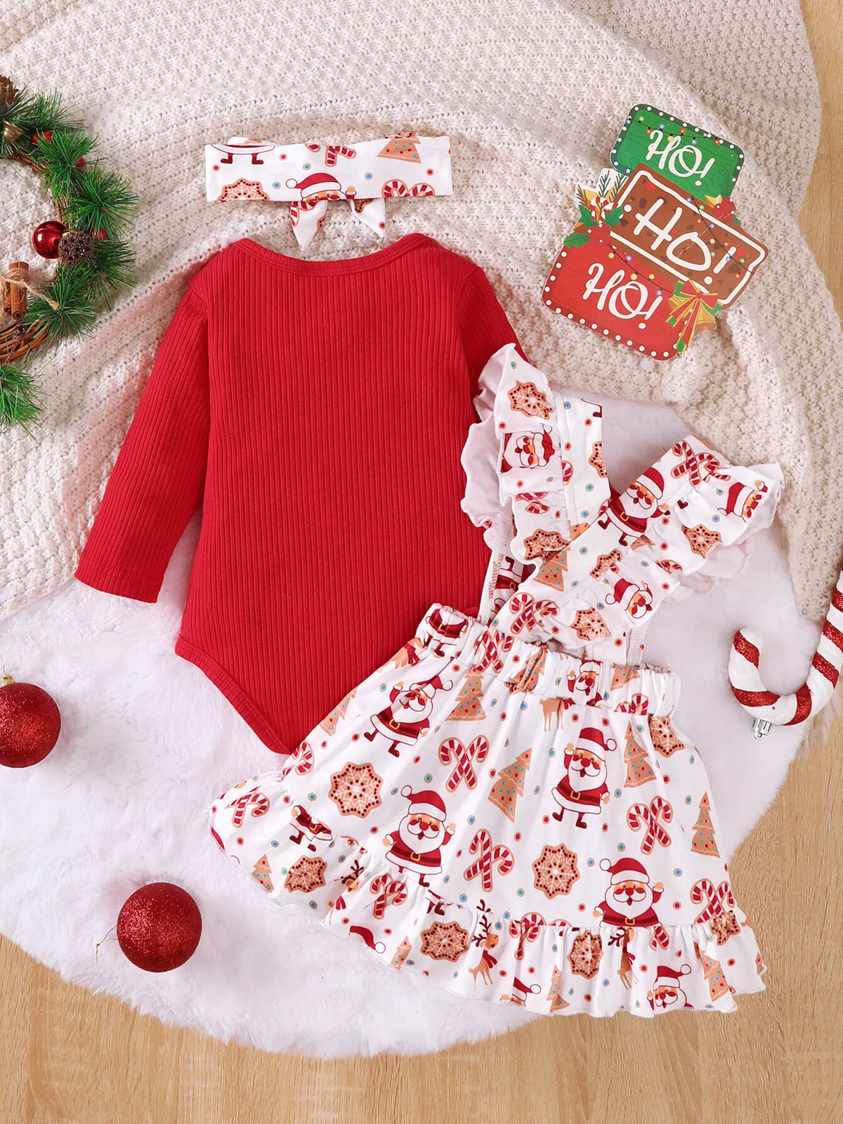 Back flat lay of the red bodysuit, Santa-print suspender skirt and matching headband.