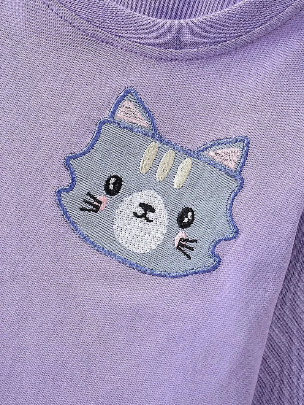 Blue and gray cat-face graphic on the purple sweatshirt
