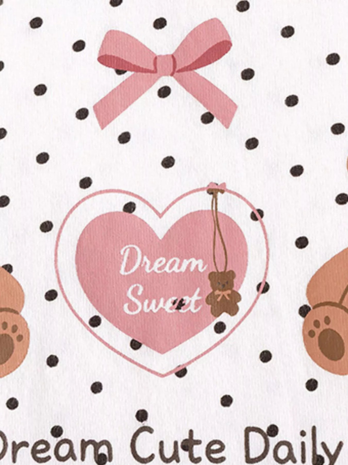 Bear, bow and pink dream-catcher graphic on the white polka-dot top