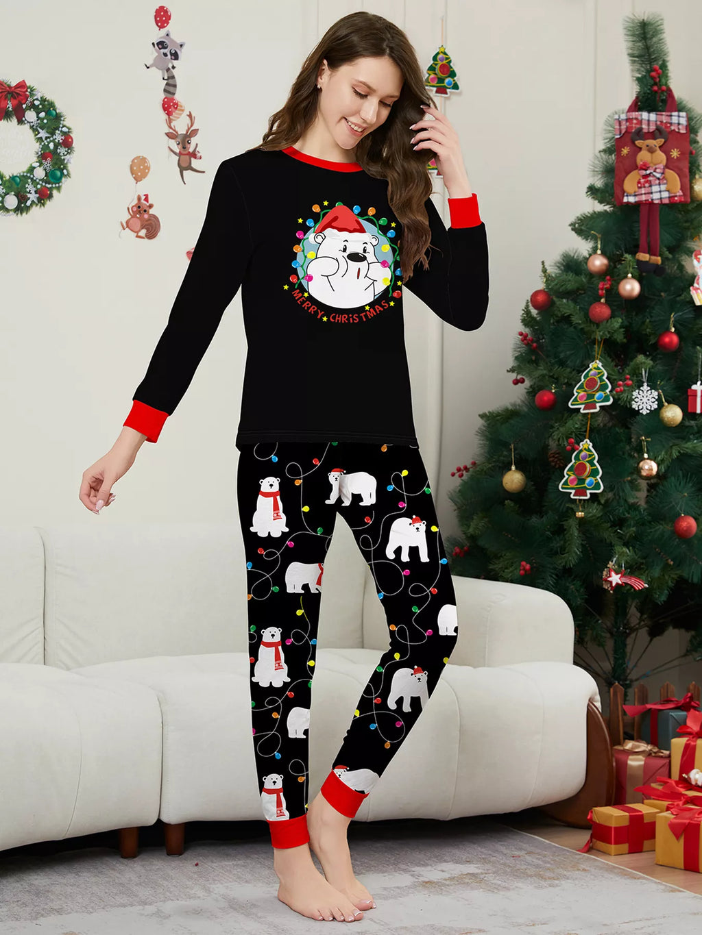 Woman modeling a black Christmas graphic top and black polar-bear-print pajama pants.