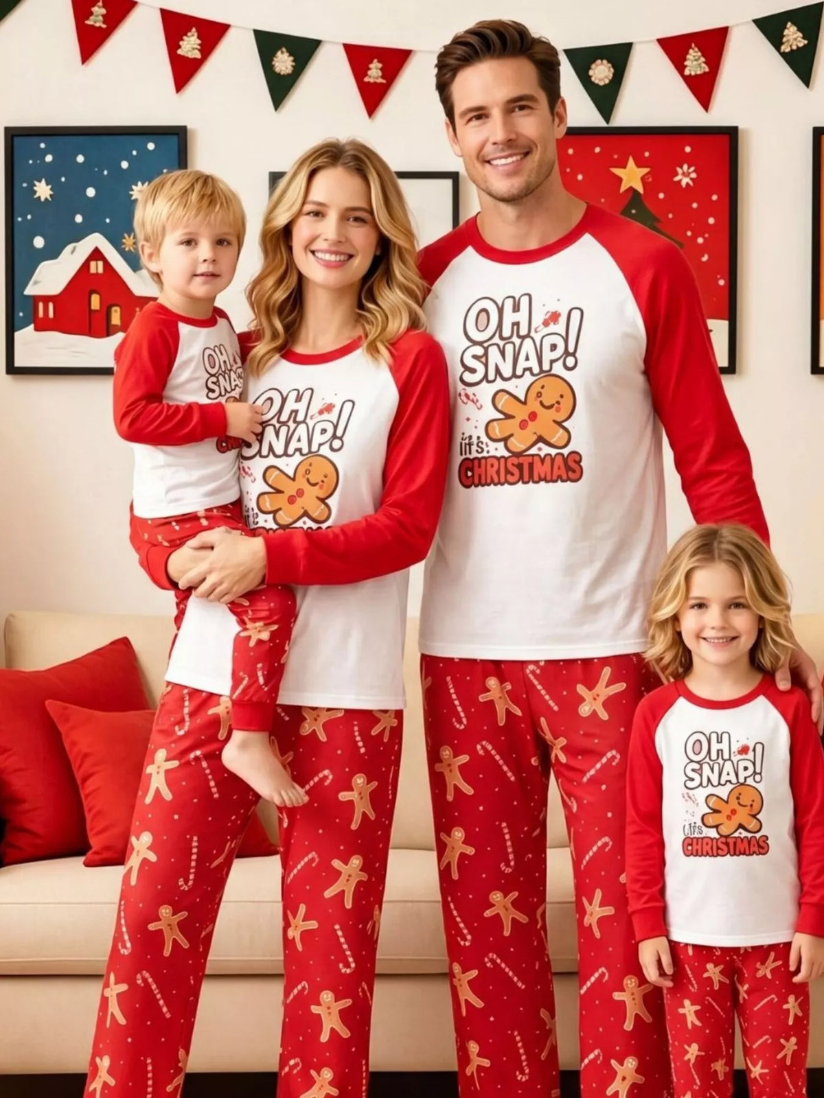 Family wearing matching white Oh Snap gingerbread graphic tops with red sleeves and red printed pajama pants.