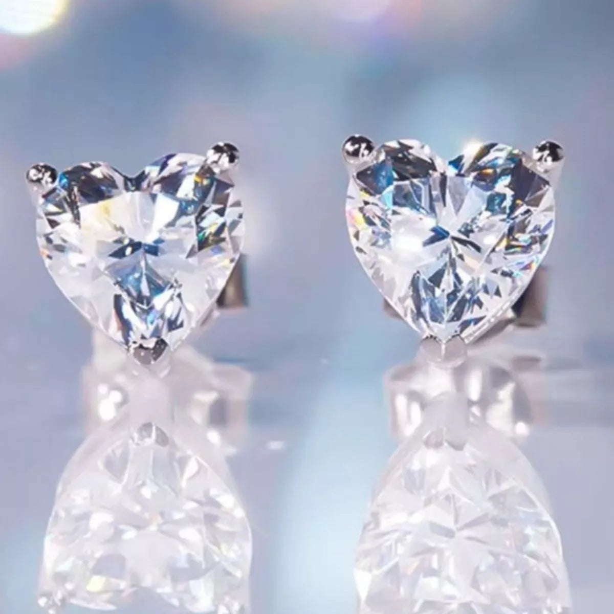 Silver-tone heart-shaped clear stone stud earrings — detail view