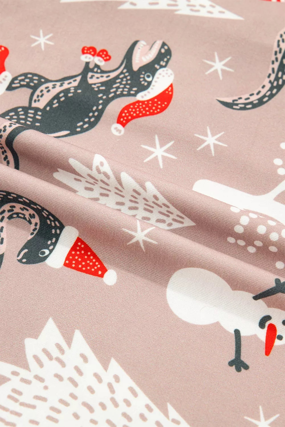 Pink long-sleeve pajama shirt and pants with dinosaur Christmas print — detail view