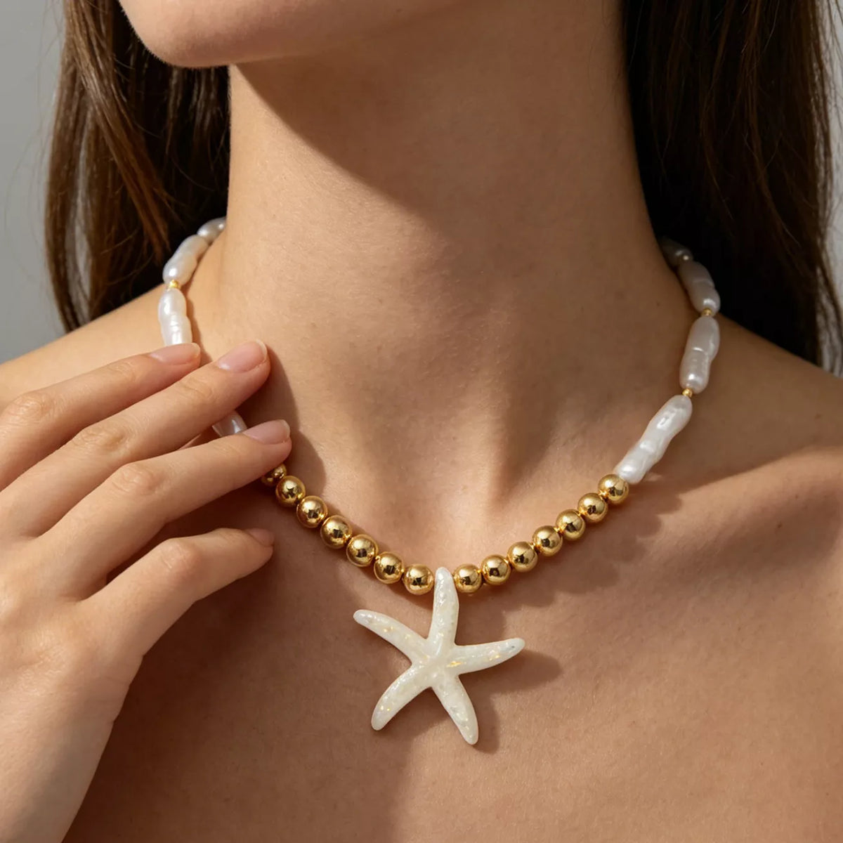 Starfish pendant necklace with gold-tone beads and white shell-like links