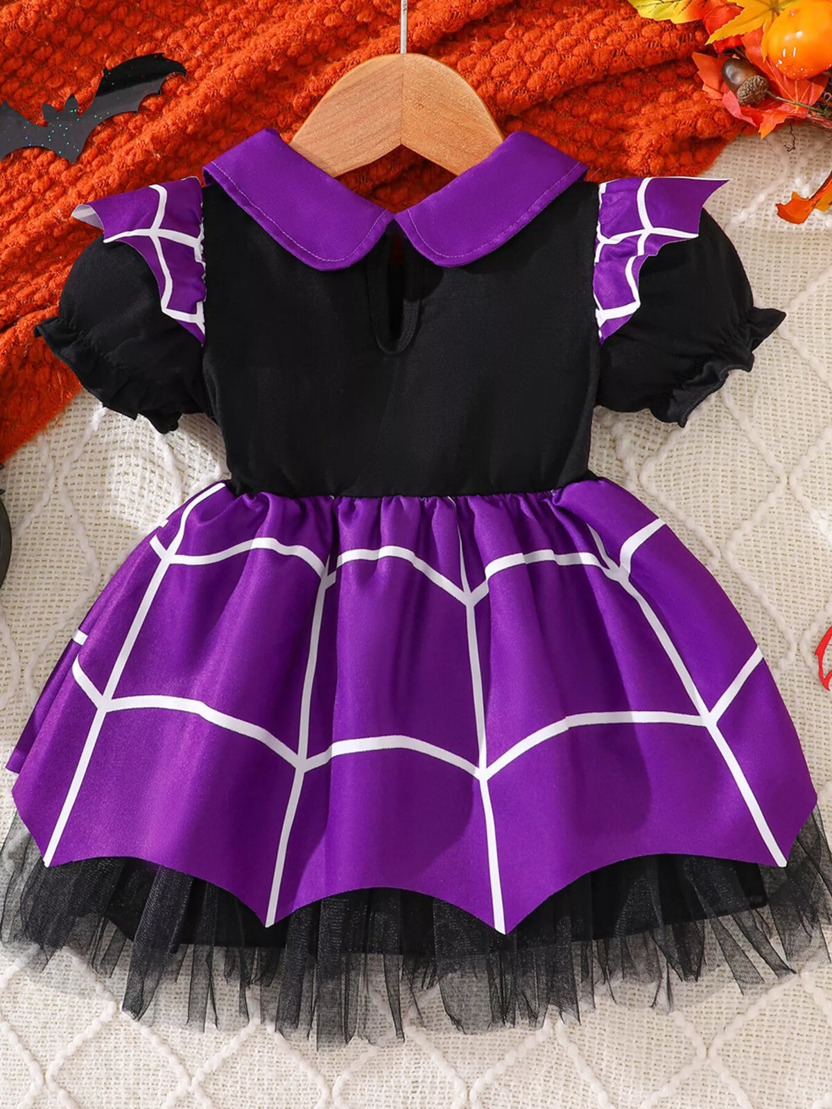 Back flat lay of the black and purple spiderweb Halloween dress.