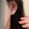 Silver-tone stud earrings with clear faceted stones — detail view