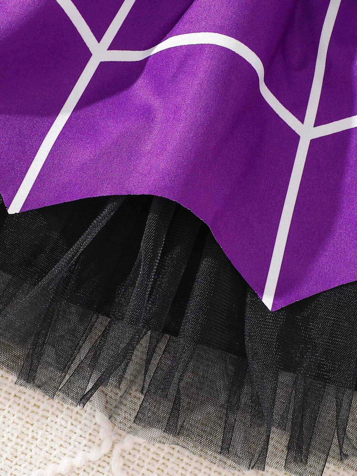 Close-up of the purple spiderweb skirt overlay and black tulle hem.