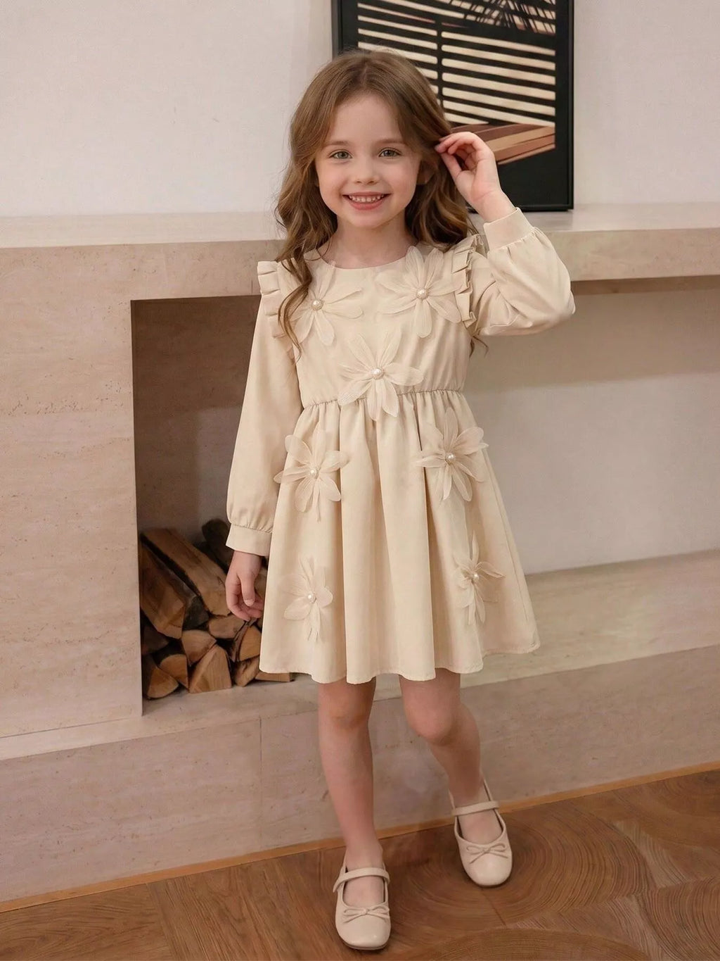 Child wearing a cream long-sleeve dress with large floral appliques.
